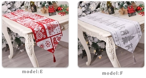 Close-up of red and grey knitted Christmas table runners with tassels on a white table