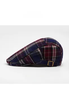Détail latéral de la casquette plate à carreaux avec boucle en métal doré ajustable