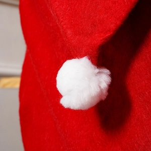 Close-up of a soft red Christmas chair cover featuring a white plush pom-pom detail