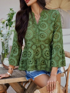 Vue détaillée du chemisier vert à col en V en broderie anglaise avec ourlet basque et manches évasées