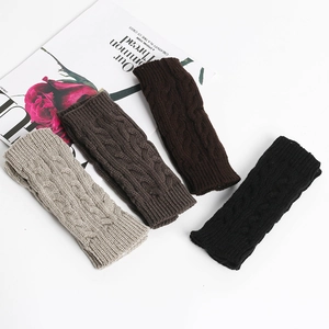 Flat lay of knit fingerless gloves in four colors with vintage cable pattern texture