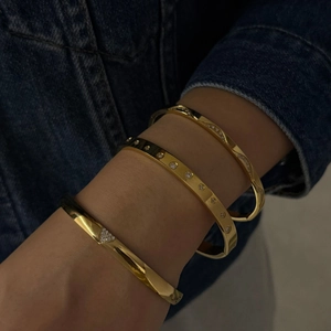 Ensemble de trois bracelets en acier inoxydable plaqué or avec zircons portés au poignet