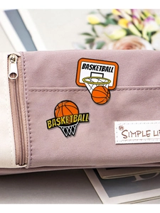 Detailed macro view of basketball enamel pins on a purple fabric bag surface