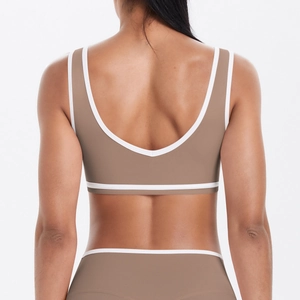 Gros plan d'une brassière de sport taupe avec bordure blanche contrastée et dos ouvert