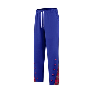 Détail du jogging bleu avec boutons rouges et patchwork à carreaux verts latéraux