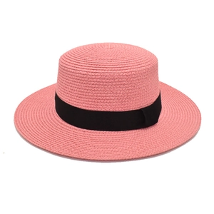 Detail of pink straw sun hat with flat top and elegant black bow ribbon tie