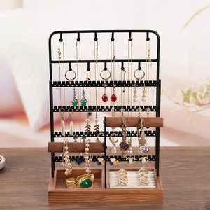 Large black metal jewelry organizer with wooden earring hooks and a bracelet display stand