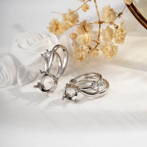 Basi per anelli in argento a quattro griffe con zircone su tessuto floreale bianco