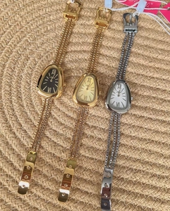 Detailed macro view of snake head shaped quartz watches with metal fringe chain bands