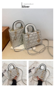 Silver heart quilted top handle handbag with elegant gold-tone hardware and charm