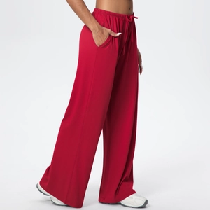 Detail of dark red wide-leg trousers with drawstring waist and functional side pockets