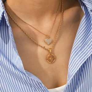Layered gold heart and sun compass pendant necklace with sparkling rhinestones on model