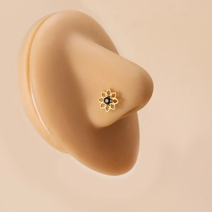 Gold stainless steel nose stud with floral zircon design on a silicone nose model