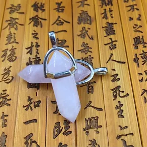 Natural rose quartz hexagonal prism pendants with silver metal clasps on bamboo surface