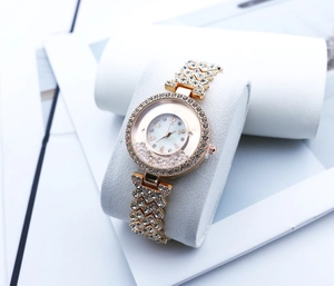 Detail of rose gold rhinestone watch dial with floating crystals and numeral markers
