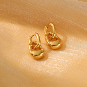 Elegant gold drop earrings on silk fabric showcasing luxury stainless steel fashion