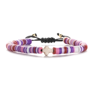 Detail of colorful polymer clay heishi bead bracelet with white stone cross and pull cord