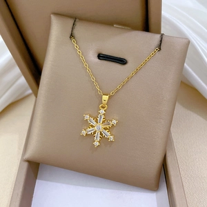 Makroaufnahme des goldenen Schneeflocken-Anhängers mit Zirkonia auf Schmuckkarte