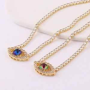 Detailed close-up of gold evil eye necklaces with inlaid white and blue zircons