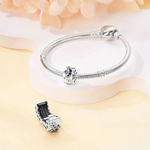Macro detail of silver moon and star charms with blue zircons on a snake bone bracelet