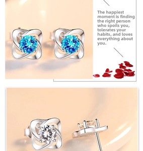 Macro detail of S999 sterling silver four-leaf clover stud earrings with sky blue gemstone