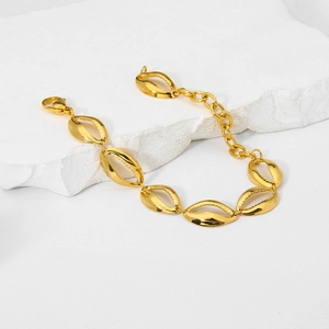 Detail of 18K gold plated shell texture bracelet links on a white stone background