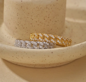 Detailed close-up of gold and silver chain rings with pave-set shimmering zircon stones