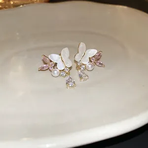 Silver needle butterfly earrings with pearls and waterdrop zircon in a ceramic dish
