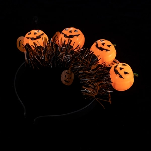 Close-up of glowing orange pumpkin jack-o-lanterns with metallic tinsel on headband