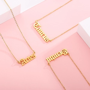 Detailed shot of gold-plated Aries Taurus and Gemini gothic letter pendant necklaces