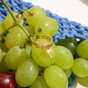 Dettaglio dell'anello in acciaio inossidabile oro 18K con ciondolo a palma su uva verde
