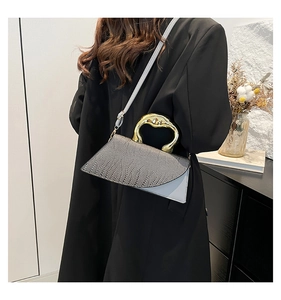 Detail of dark grey crocodile texture bag with light blue leather and gold handle