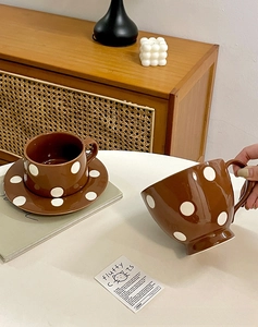 Détail de mugs nordiques en céramique à pois blancs avec leur soucoupe assortie