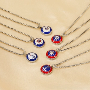 Macro shot of stainless steel nautical necklaces with compass, rudder, and anchor pendants