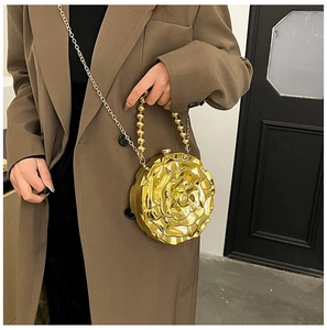 Close-up of golden rose-shaped evening clutch bag with chain strap and beaded handle