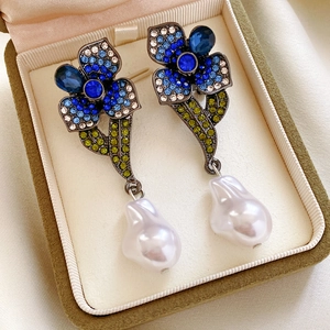 Détail macro de boucles d'oreilles vintage avec perles et cristaux sur velours