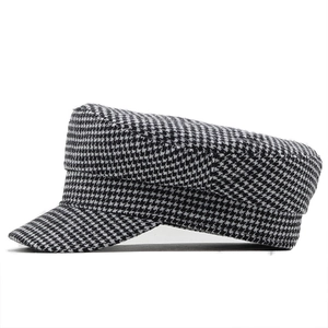 Side view of newsboy cap with classic black and white houndstooth wool texture
