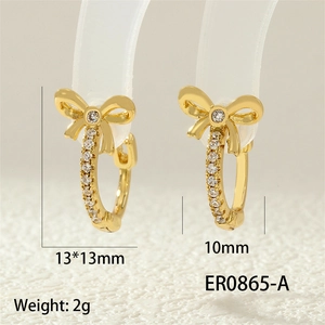 Detailed view of 13x13mm gold bow earrings with white zircon on transparent stand