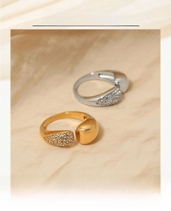 Detail of gold and silver open rings with teardrop metal and pavé crystal accents