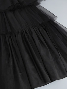 Detailed macro shot of layered black mesh fabric showing delicate pleats and texture