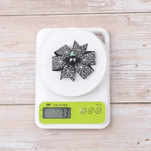 Halloween spider web bow hair clip weighing 7.3g on an electronic scale for kids