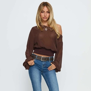 Detail der transparenten braunen Off-Shoulder-Bluse mit Laternenärmeln und feiner Textur