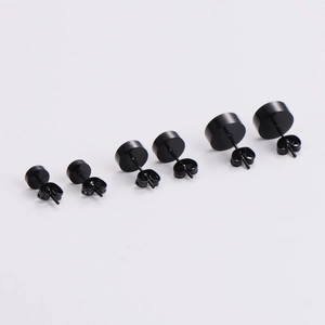 Set of three black stainless steel round stud earrings in varying sizes on white background