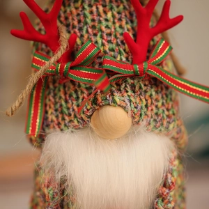 Close-up of Christmas gnome detail with red antlers and knitted hat on festive plush toy