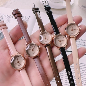 Close-up of five colorful leather strap quartz watches with rose gold cases on a magazine