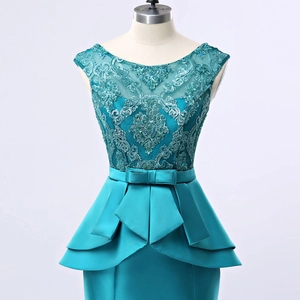 Robe de soirée bleu paon avec broderie en dentelle, paillettes et détail de peplum