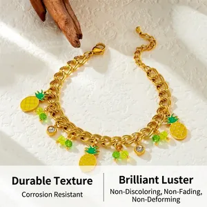 Close-up of gold chain bracelet with enamel pineapple charms and green crystal beads