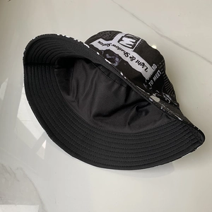 Close-up of black fisherman hat with white newspaper print and double-layer lining