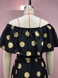 Detail eines schwarzen Kleides mit gelben Punkten und gerafftem schulterfreiem Design