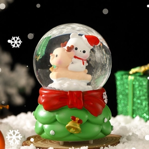 Christmas snow globe with bear and reindeer inside a green Christmas tree base